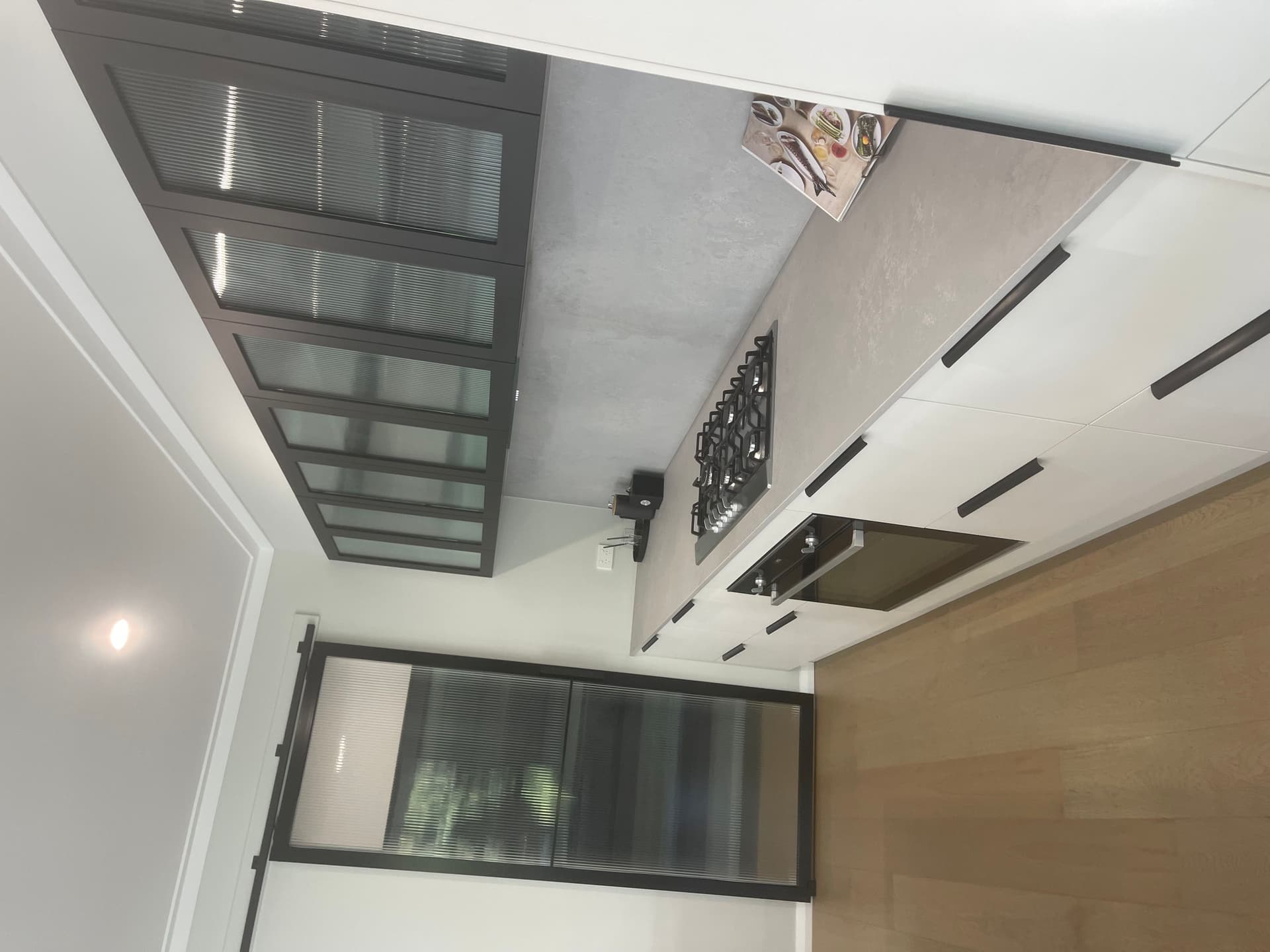 Modern kitchen after professional end of lease cleaning, including deep cleaned oven, cooktop, cabinets, benchtops, and polished timber floors.